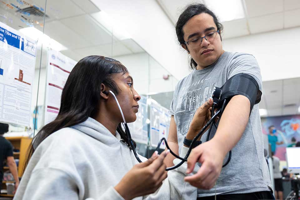 A student takes another students blood pressure.