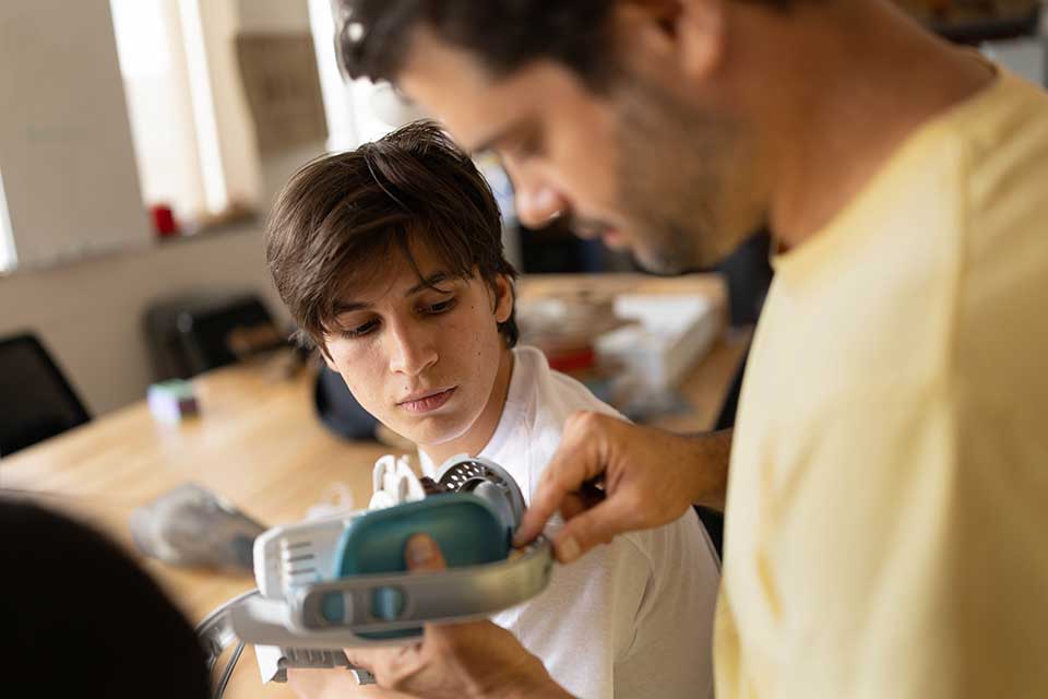 A student and faculty member in an engineering classroom
