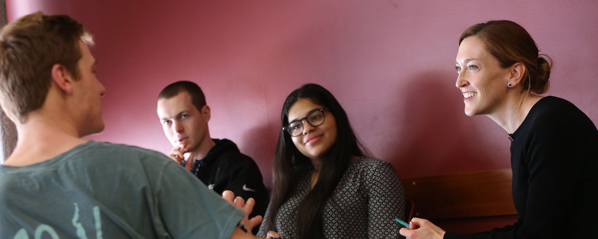 Professor Jill Greenlee sits with students, talking happily