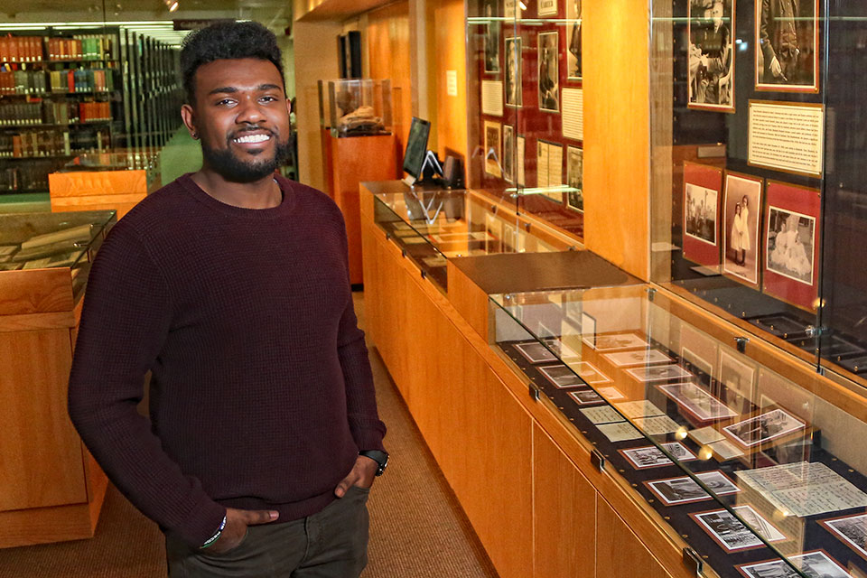 Joel Burt-Miller stands in the library