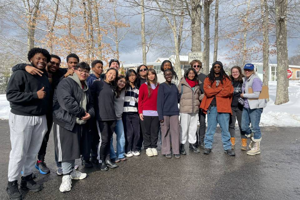 A large group of students smiles and poses for the camera