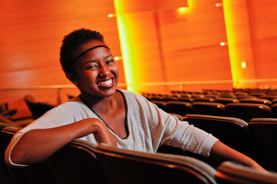 LaShawn Simmons sitting in an auditorium filled with orange light