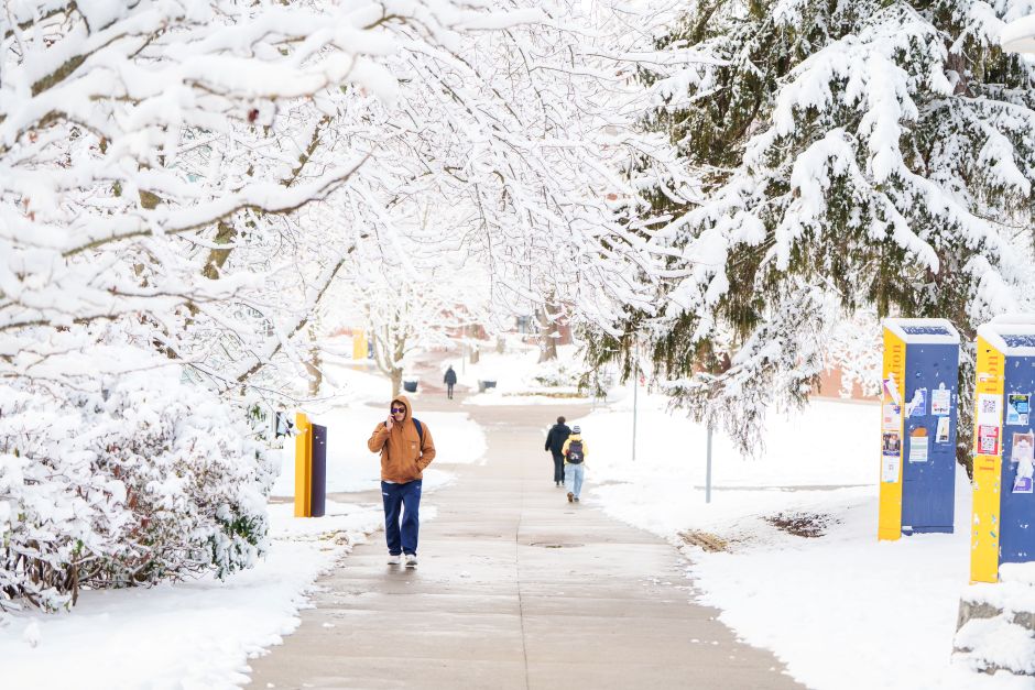 student walks down snow covered campus path