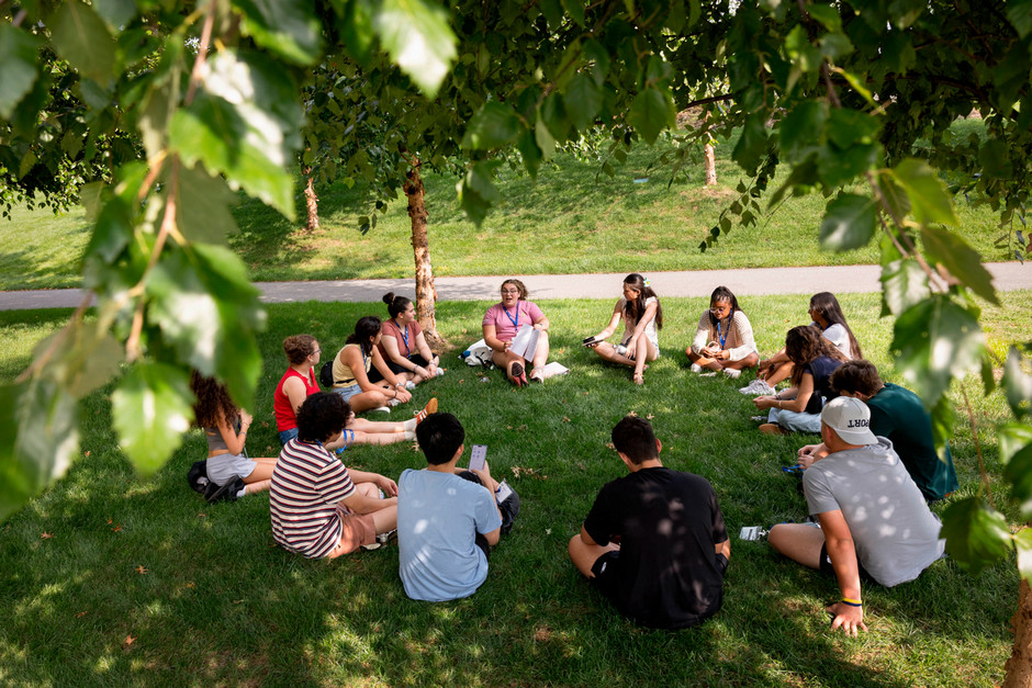 students sit outside on bench