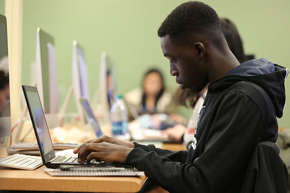 Student seated at a computer lab table during a psychology class