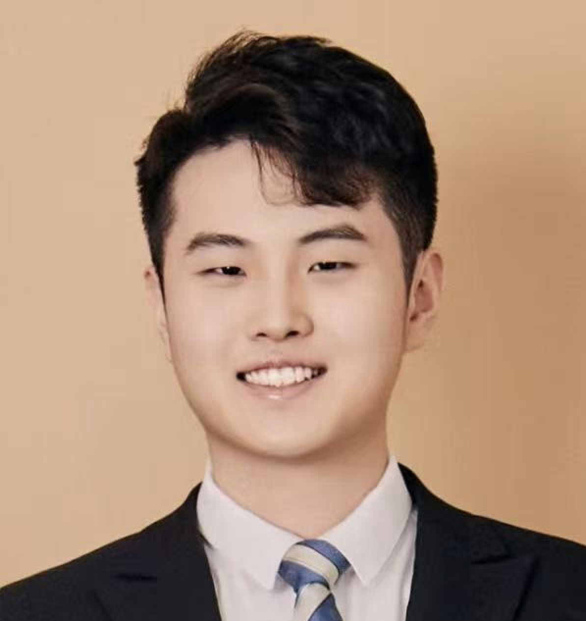 Asian male with dark hair wearing a blue and white striped tie against an orange background