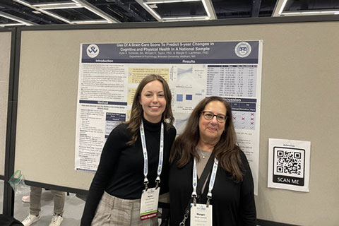 Lifespan Lab researchers in front of a lab poster.
