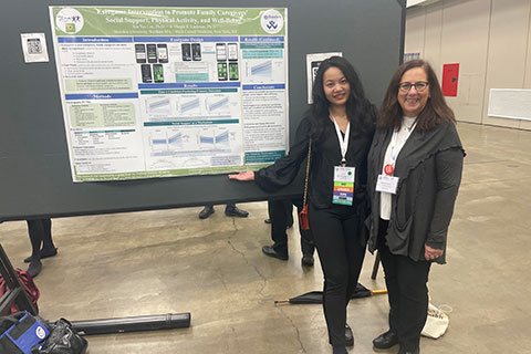 Two people standing in front of a research poster.