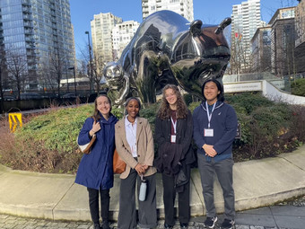 lab members, claire, daisy, emma and patrick standing infornt of bear statues in vancouver.