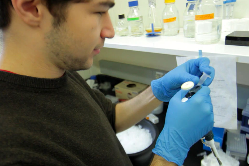 Gil Henkin holding equipment in a lab