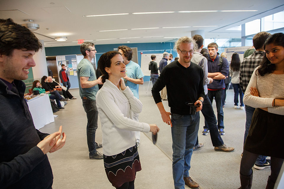 Avi Rodal and other faculty members discussing scientific posters