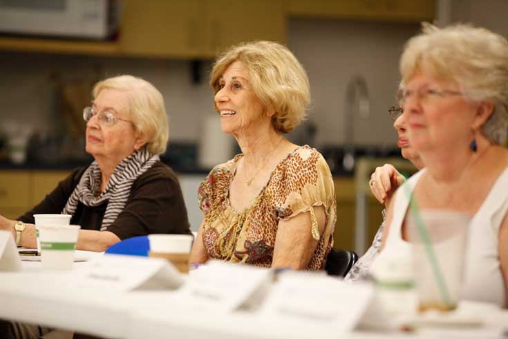 A woman smiles while sitting at a table with others