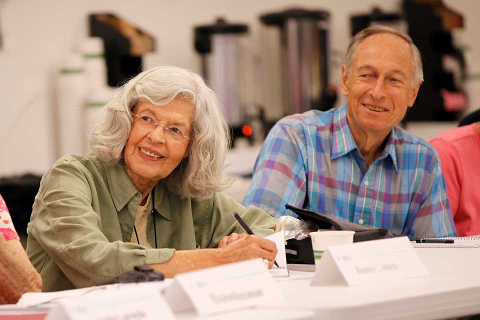 Older adults smile while taking notes