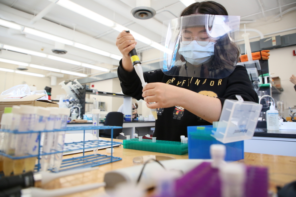 A student in the lab wearing a mask