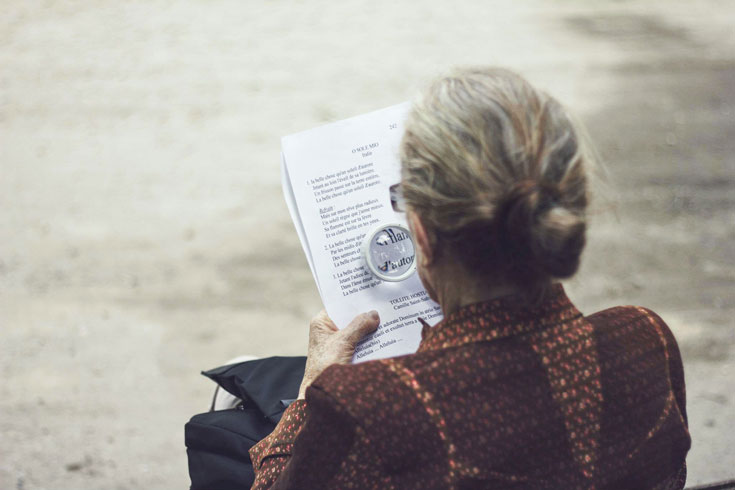 woman reading with a magnifying glass