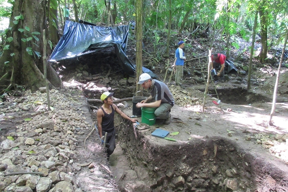 Charles Golden kneels at dig site