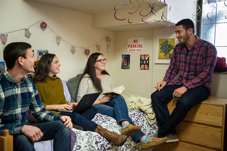 Color photo of four people in a residence hall