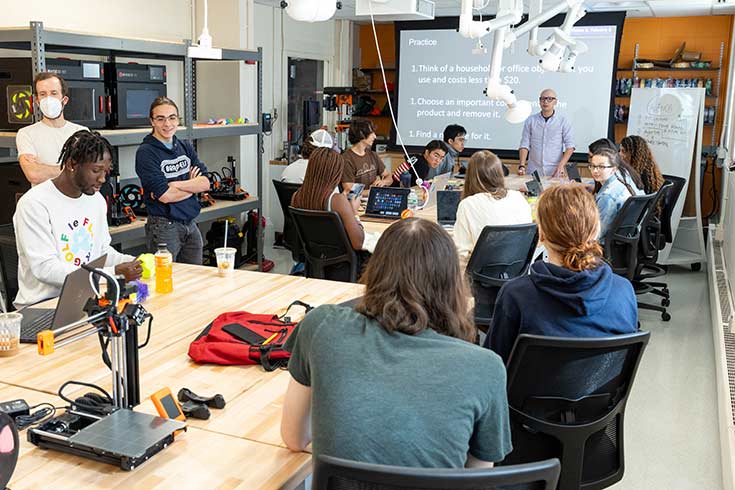 Color photo of people engaging in hands-on discovery in an engineering classroom