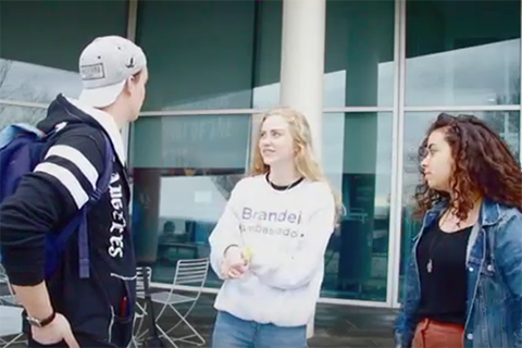 a male student and two female students standing in front of the student center talking to each other