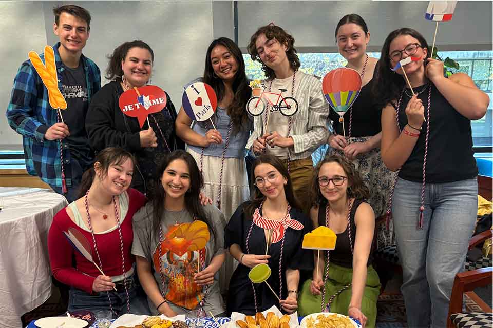 Students at the French majors party holding French photo props