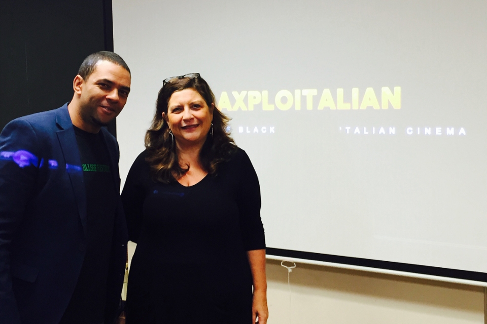 photo of Fred Kuwornu and Paola Servino standing in front of powerpoint projection screen that says Blaxploitalian