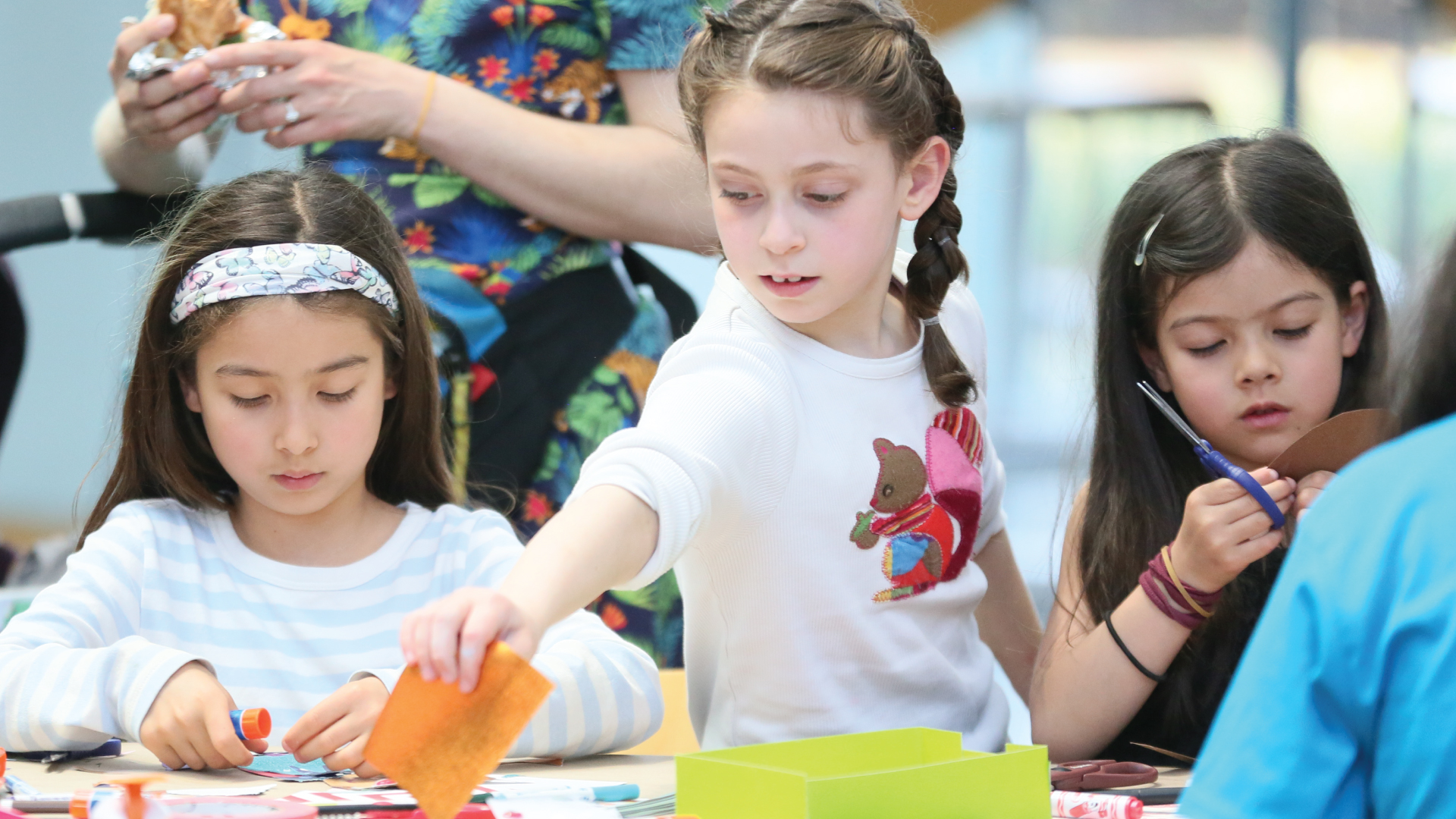 Three young children participating in an artmaking activity