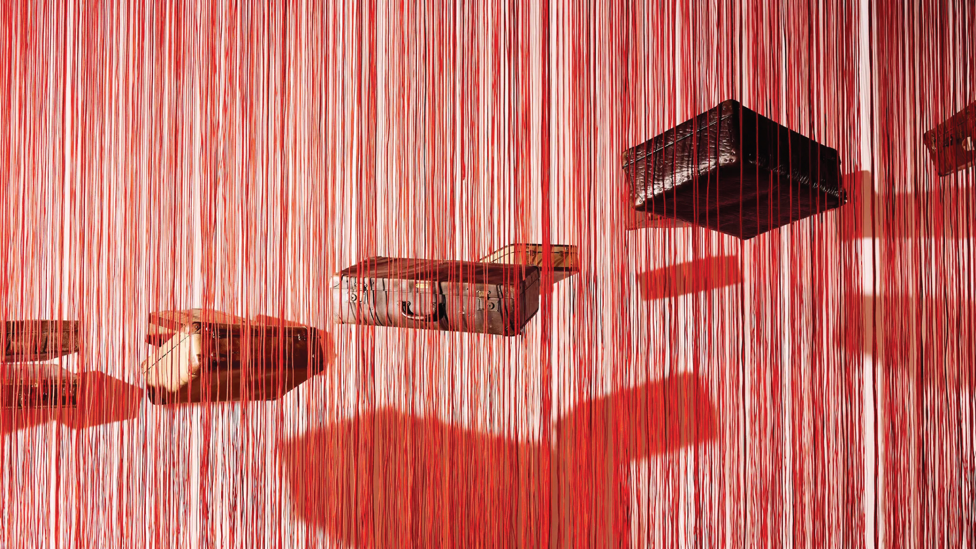 Antique suitcases suspended by red string