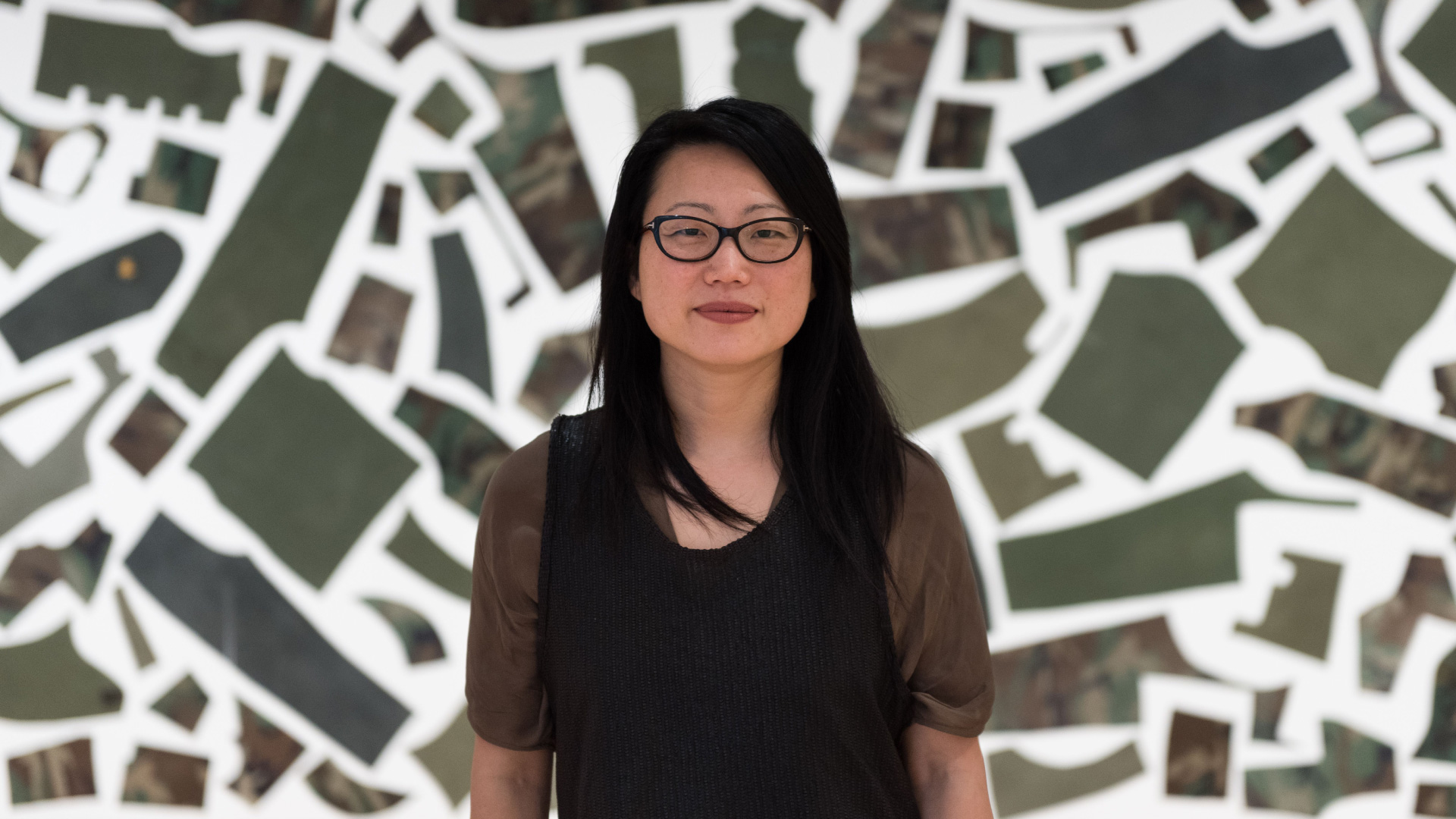 Artist Jean Shin standing in front of a one of her artworks