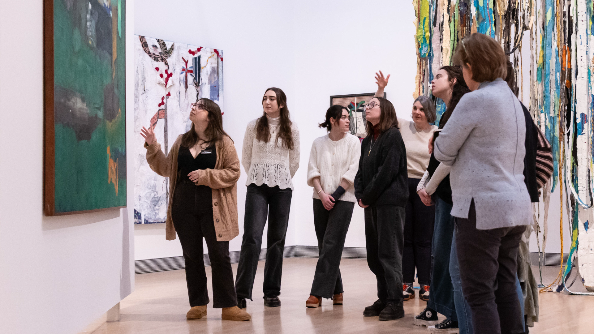 Student docent discussing a work of art with a group of visitors