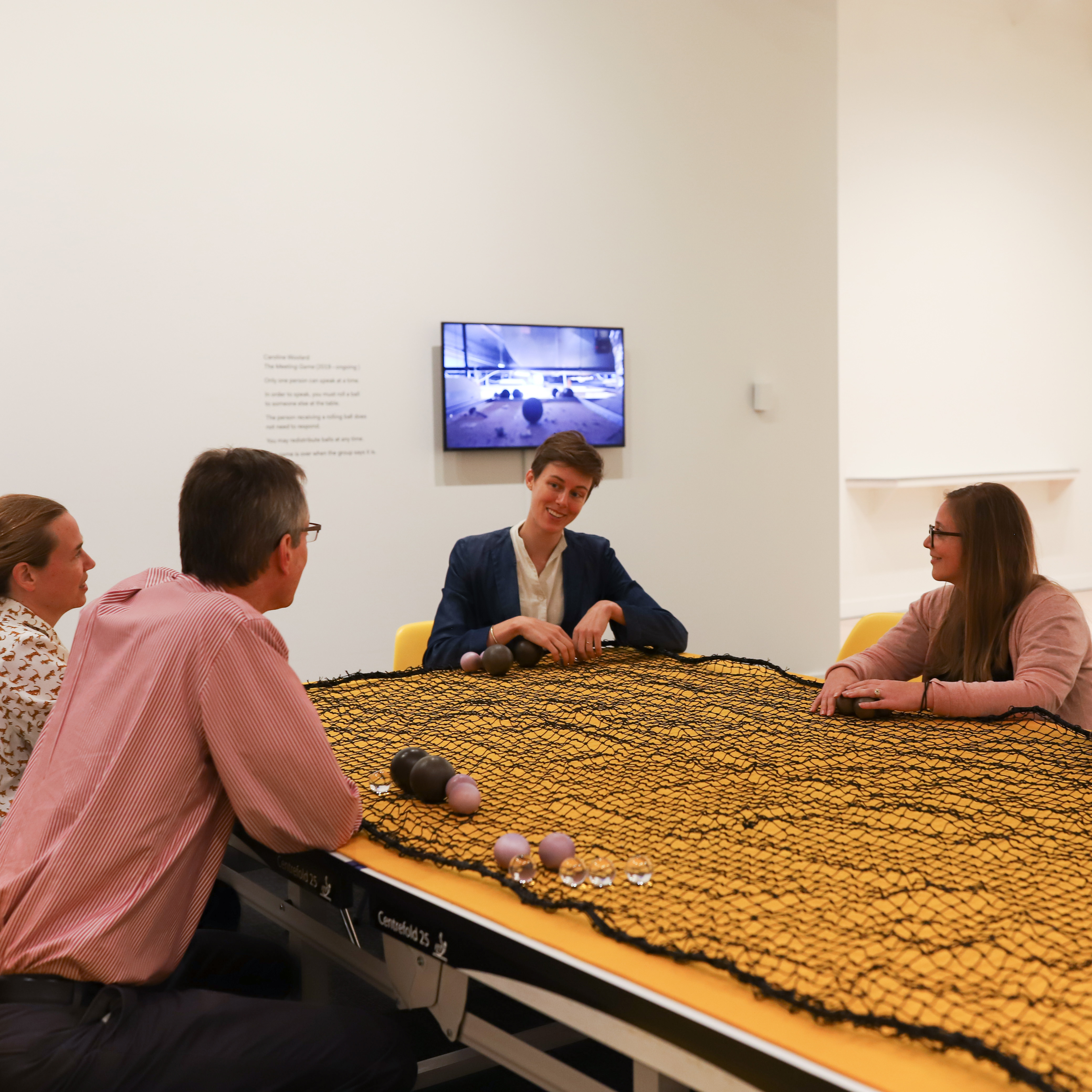 People sitting around a yellow table smiling and talking