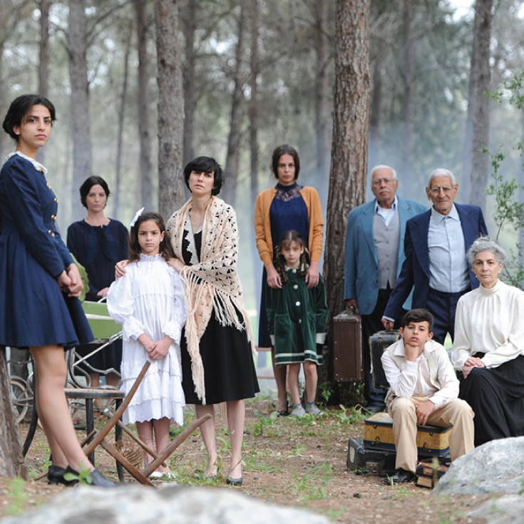 A group of people standing in a forest with luggage.