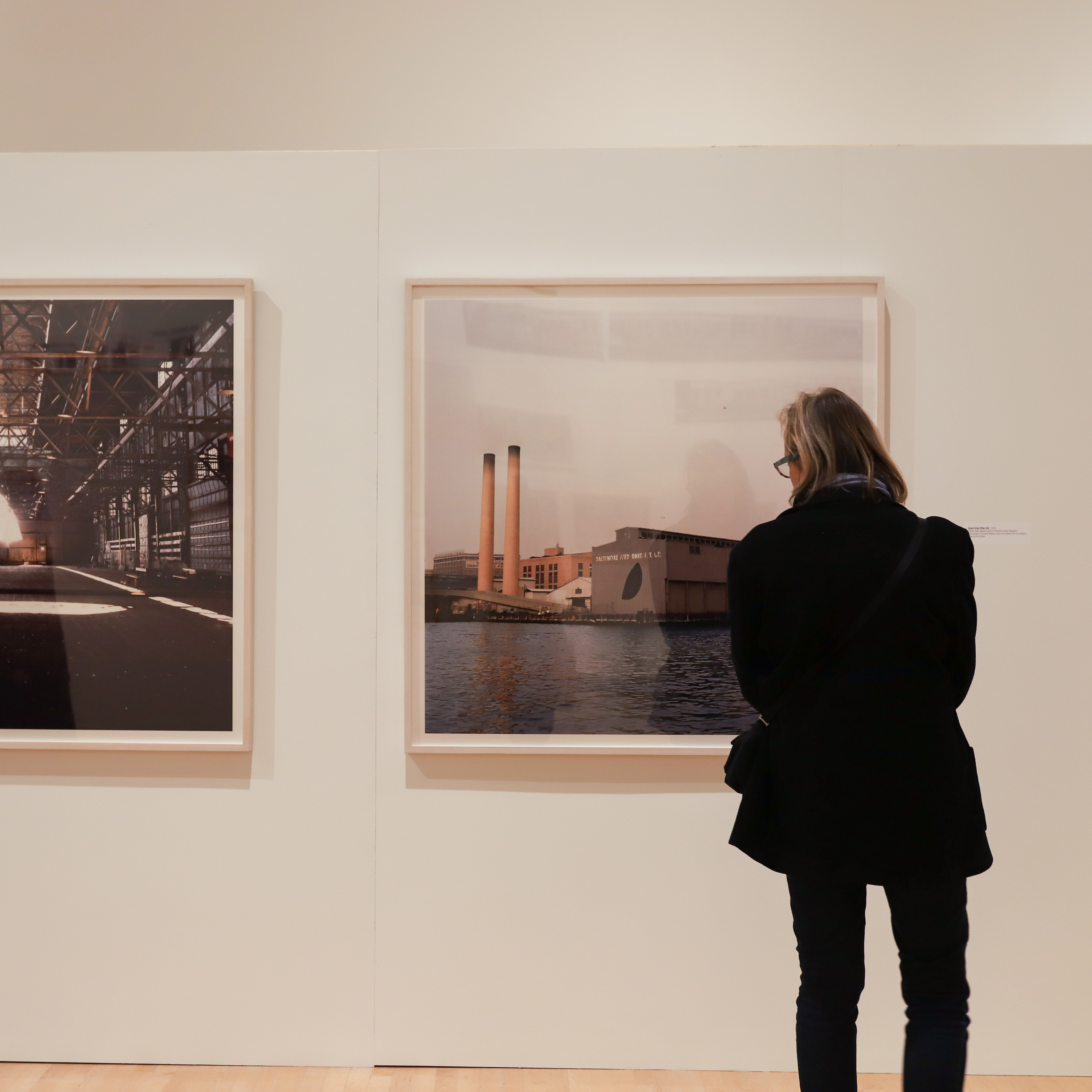 Visitor looking at two photographs in the Gordon Matta-Clark exhibition