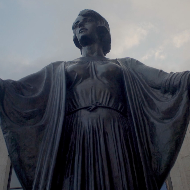 Film still from Love with Obstacles featuring Film title and a sculpture