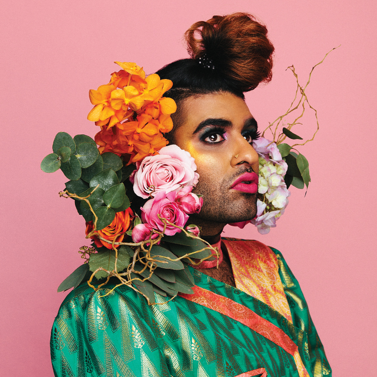 Portrait of non-binary activist and writer ALOK with flowers in their hair.
