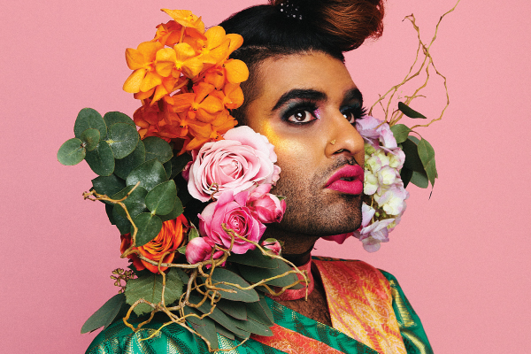 Portrait of non-binary activist and writer ALOK with flowers in their hair.