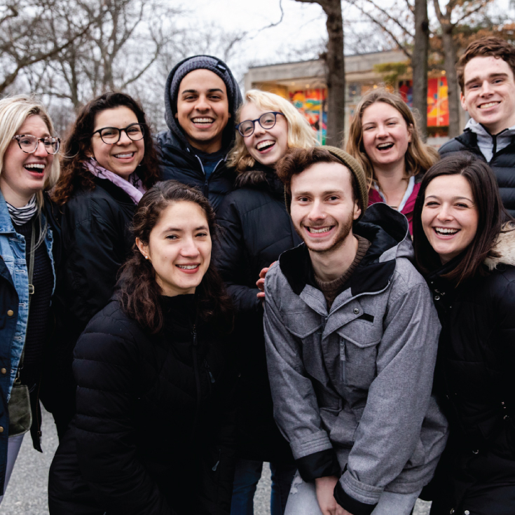 A group of students posing in front of the lamp posts.