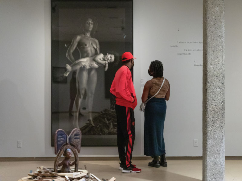 A man and woman looking at a photograph in the museum's gallery.