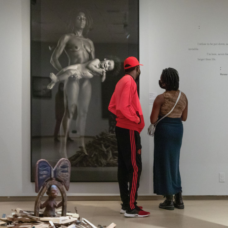 A man and woman looking at a photograph in the museum's gallery.