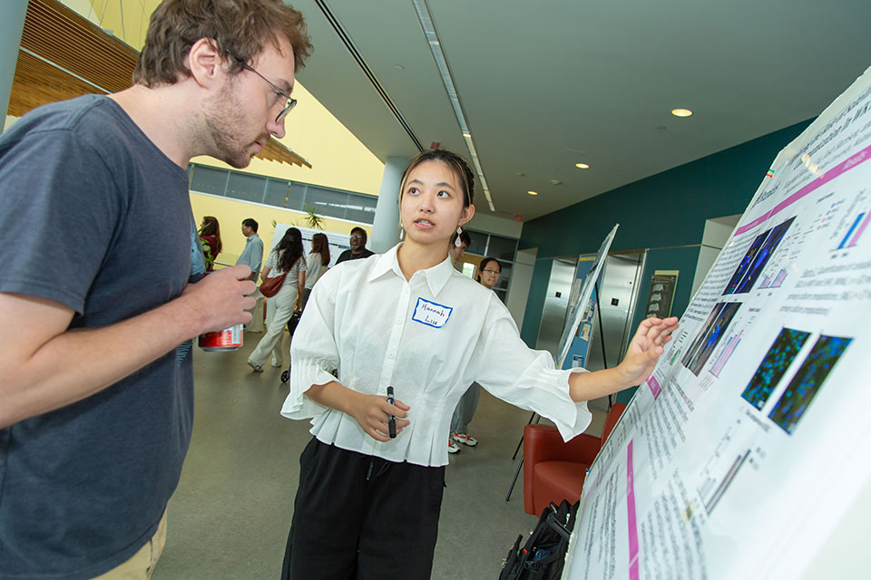 A student explaining their research poster.