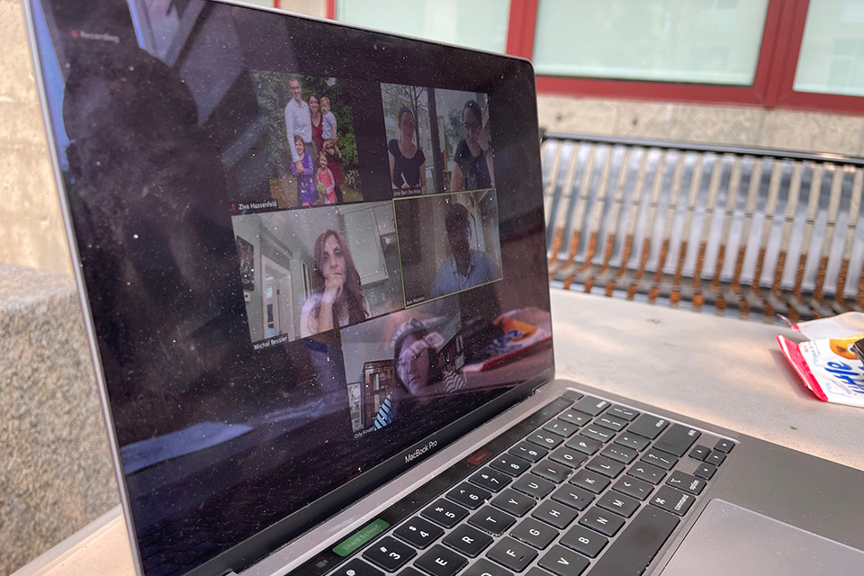 A laptop screen showing a Zoom meeting in progress with teachers and student researchers.