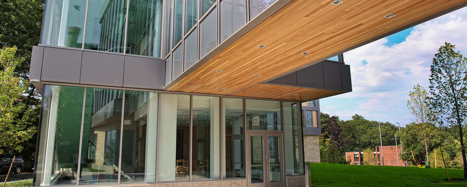 Entrance of Skyline Residence Hall with reflection of Castle flag in the window