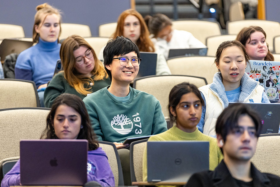 Several students seated in a classroom, engaged in discussion