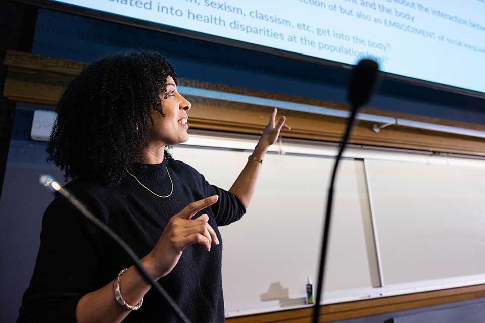 Associate Professor of Sociology Siri Suhpoints at a white board