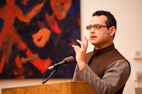 Vijay Prashad standing at a podium speaking