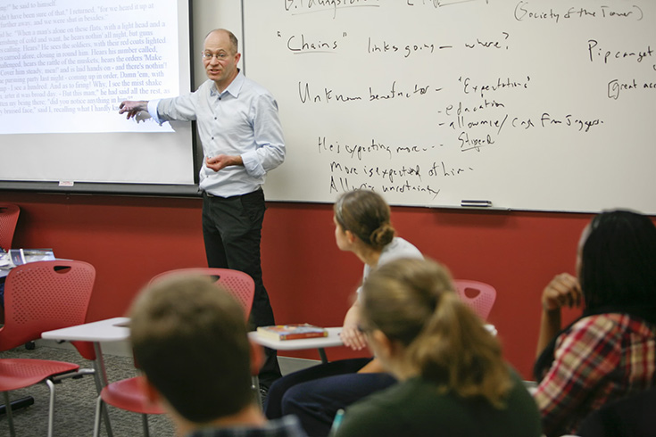 Faculty member at whiteboard teaching a class