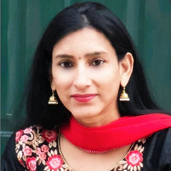 a headshot of an Indian woman in colorful top