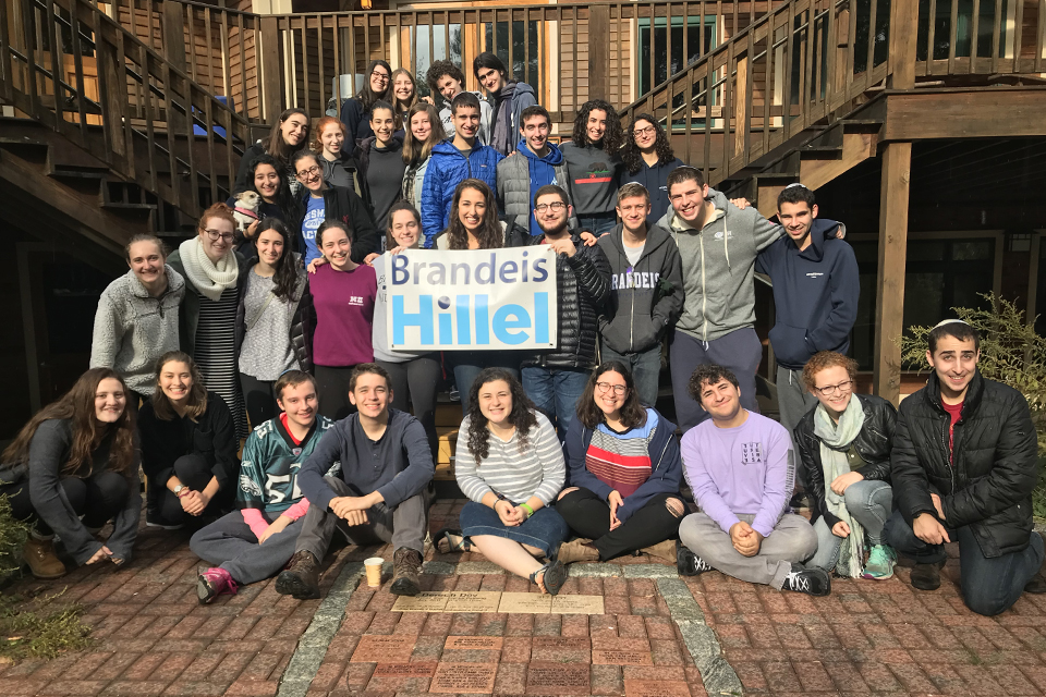 picture of a large group of students holding a sign that says Brandeis Hillel