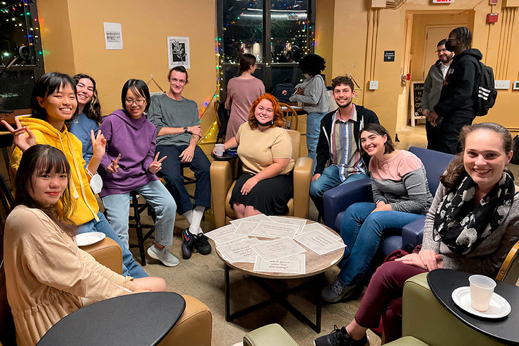 a group of students sitting in a circle at Chum's, looking at the camera