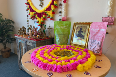 Colorful round dessert on the right with two bags of tea beside it, and an altar on the left