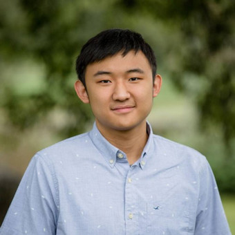 head shot of an Asian man in his 20s or 30s in a blue buttoned shirt